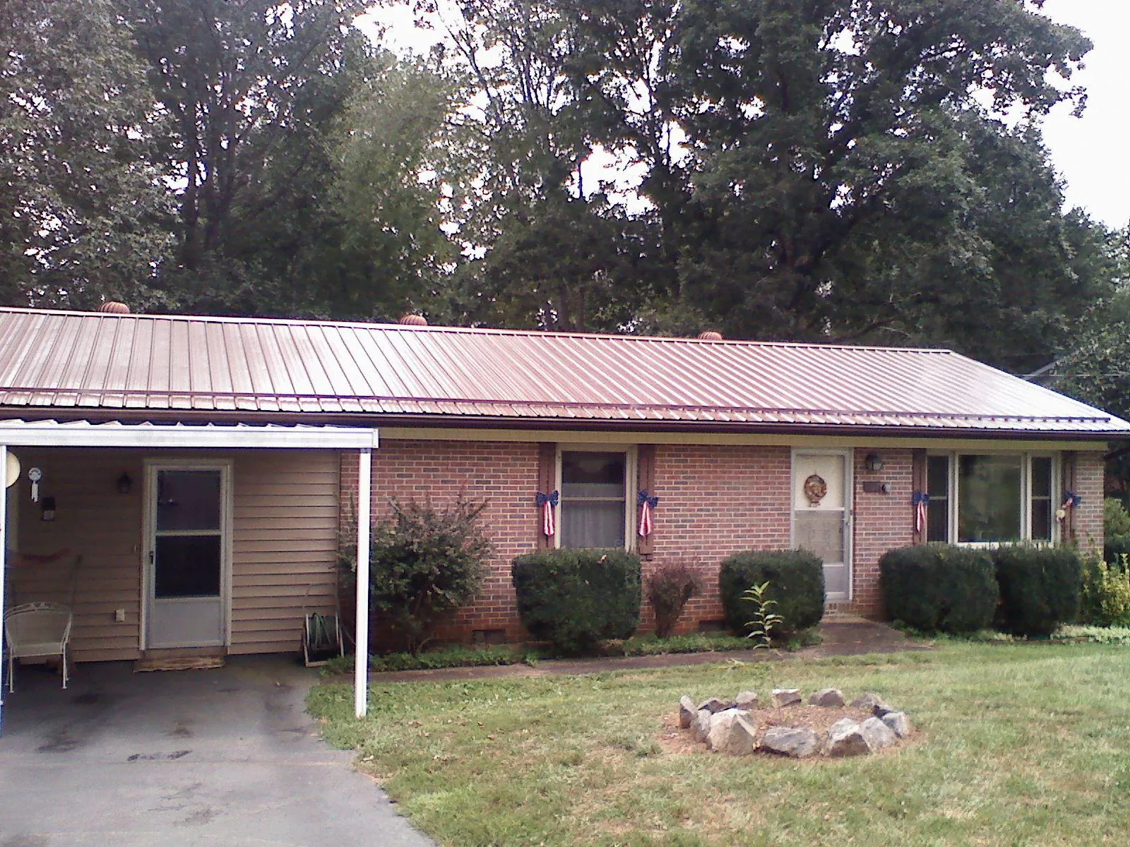 Bronze metal roof and carport on a brick ranch home — Roof Repair work by our crew in Arlington